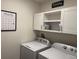 Bright laundry room with washer, dryer, and ample cabinet space at 3033 Meleto Blvd, New Smyrna Beach, FL 32168