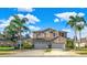 Two-story house with three-car garage, palm trees, and manicured lawn at 310 La Creek Ct, Debary, FL 32713