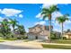 Two-story house with three-car garage, palm trees, and manicured lawn at 310 La Creek Ct, Debary, FL 32713