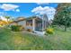 Backyard view of home with screened patio and lush landscaping at 310 La Creek Ct, Debary, FL 32713