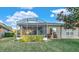 Home exterior showcasing a screened patio and landscaped yard at 310 La Creek Ct, Debary, FL 32713