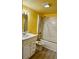 Bathroom with yellow walls, tub shower, and updated vanity at 334 Scottsdale Sq # 334, Winter Park, FL 32792