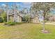 Tan house with palm trees and manicured lawn at 34 Black Creek Way, Ormond Beach, FL 32174