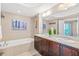 A spacious bathroom with double sinks, a soaking tub, and light brown tile flooring at 3737 S Atlantic Ave # 502, Daytona Beach, FL 32118