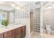 Well-lit bathroom featuring a walk-in shower with glass block and dark wood cabinets at 3737 S Atlantic Ave # 502, Daytona Beach, FL 32118