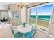 Inviting dining area with a window showcasing ocean views, complemented by a round table and comfortable seating at 3737 S Atlantic Ave # 502, Daytona Beach, FL 32118