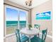 Bright dining area with a white table, blue chairs, and a large window showcasing beautiful ocean views at 3737 S Atlantic Ave # 502, Daytona Beach, FL 32118