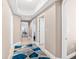 Hallway with a geometrically patterned rug, tray ceilings and access to several rooms at 3737 S Atlantic Ave # 502, Daytona Beach, FL 32118