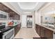 Bright kitchen with stainless appliances, dark wood cabinetry, granite countertops and travertine floors at 3737 S Atlantic Ave # 502, Daytona Beach, FL 32118
