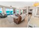 Inviting living room with leather sofas, an open floorplan and a sliding glass door leading to a balcony with ocean views at 3737 S Atlantic Ave # 502, Daytona Beach, FL 32118
