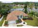 Aerial view of a green home with brown roof, water view, and large yard at 39 Ormond Green Blvd, Ormond Beach, FL 32174