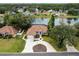Aerial view of a green home with brown roof, circular driveway, and water view at 39 Ormond Green Blvd, Ormond Beach, FL 32174