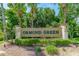View of the Ormond Green community entrance sign with manicured landscaping and mature palm trees at 39 Ormond Green Blvd, Ormond Beach, FL 32174