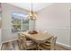 Dining room featuring an elegant chandelier, wood-look floors, and natural light from a large window at 39 Ormond Green Blvd, Ormond Beach, FL 32174