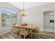Bright dining room with a table set for six, an arched window, and wood-look floors, perfect for hosting gatherings at 39 Ormond Green Blvd, Ormond Beach, FL 32174