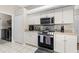 Close up of the kitchen showing stainless steel oven, microwave, and tile backsplash at 39 Ormond Green Blvd, Ormond Beach, FL 32174
