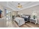 Comfortable main bedroom with a tray ceiling, desk, and access to the patio at 39 Ormond Green Blvd, Ormond Beach, FL 32174
