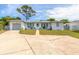 Front view of a single-story home with a light-colored exterior and a spacious driveway at 469 S Halifax Dr, Ormond Beach, FL 32176