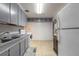 Kitchen boasts gray cabinets, white appliances, and tiled floors at 469 S Halifax Dr, Ormond Beach, FL 32176