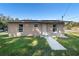 Tan single story house with a walkway, lawn, and solar panels on the roof at 501 W Lisbon Pkwy, Deland, FL 32720