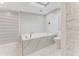 Bright bathroom featuring a modern soaking tub with a stone surround and a skylight at 681 N Halifax Dr, Ormond Beach, FL 32176
