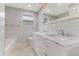 Bathroom featuring a double vanity with marble countertops and a separate tub and toilet area at 681 N Halifax Dr, Ormond Beach, FL 32176