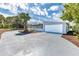 Driveway leading to a pristine garage framed by meticulous landscaping and lush greenery at 681 N Halifax Dr, Ormond Beach, FL 32176