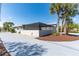 Side view of a home featuring a long driveway, landscaping, and a screened-in patio at 681 N Halifax Dr, Ormond Beach, FL 32176