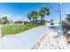 Exterior view with palm trees, lawn and a long driveway with white rock borders at 681 N Halifax Dr, Ormond Beach, FL 32176