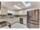 Modern kitchen featuring white cabinets, stone countertops, stainless steel appliances, and dual skylights at 681 N Halifax Dr, Ormond Beach, FL 32176