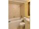 Bathroom with a tiled shower-tub combo, neutral fixtures, and a bright vanity area at 701 Perkins St # 100, Leesburg, FL 34748