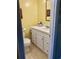Well-lit bathroom featuring a vanity with storage, a toilet, and tiled floors at 701 Perkins St # 100, Leesburg, FL 34748
