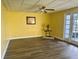 Spacious living room with wood-look floors and access to a balcony at 701 Perkins St # 100, Leesburg, FL 34748