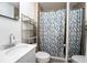 Cozy bathroom features a white vanity and tiled shower with a decorative floral curtain at 878 Abbott Ave, Deltona, FL 32725