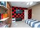 Cozy bedroom features a TV, tiled floors, red and black decorative acoustic wall panels and a ceiling fan at 878 Abbott Ave, Deltona, FL 32725