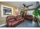 Cozy living room filled with natural light features two leather couches and a ceiling fan at 878 Abbott Ave, Deltona, FL 32725