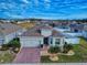 Aerial view of a single-Gathering home with a brick driveway and landscaped yard at 962 Compass Landing Dr, Orange City, FL 32763