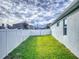 Landscaped backyard with grassy area and white fence at 962 Compass Landing Dr, Orange City, FL 32763