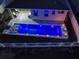 Nighttime aerial view of a rectangular pool with led lights and lounge chairs at 962 Compass Landing Dr, Orange City, FL 32763