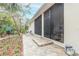 Backyard patio with stonework and access to screened porch at 123 Ponce Terrace Cir, Ponce Inlet, FL 32127