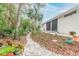 Landscaped backyard with stone pathway and tropical plants at 123 Ponce Terrace Cir, Ponce Inlet, FL 32127