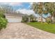 Tan paver driveway leading to a two-car garage at 123 Ponce Terrace Cir, Ponce Inlet, FL 32127