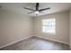 Bright bedroom with ceiling fan, large window, and grey wood-look tile floor at 130 Old Sunbeam Dr, South Daytona, FL 32119