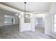 Open dining area with modern chandelier and gray floors at 130 Old Sunbeam Dr, South Daytona, FL 32119