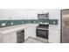 This kitchen features stainless steel appliances, quartz countertops, tile backsplash and a wine fridge at 130 Old Sunbeam Dr, South Daytona, FL 32119