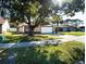 House with a large tree in front, and driveway at 1413 La Paloma Cir, Winter Springs, FL 32708