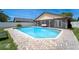 A bright, blue pool is surrounded by brick pavers and a white privacy fence with screened in patio area at 1413 La Paloma Cir, Winter Springs, FL 32708