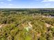 An aerial view showcasing a home's location in a quiet, wooded setting at 1908 S Farm Rd, Deland, FL 32720