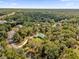 Aerial view of a home nestled in a wooded area with a long driveway at 1908 S Farm Rd, Deland, FL 32720