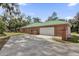 Attached brick garage with white door and driveway at 1908 S Farm Rd, Deland, FL 32720